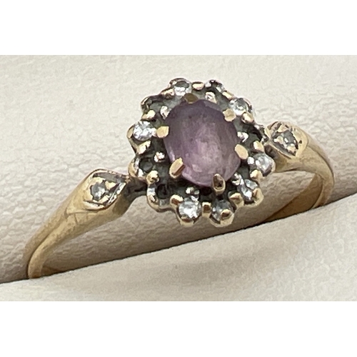 1124 - A 9ct gold, amethyst and diamond ring with central oval cut amethyst surrounded by small round cut d... 