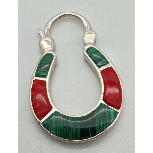 1149 - A modern silver horseshoe shaped pendant with hinged padlock fastening. Set with alternate malachite... 