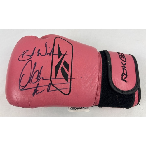 1333 - A pink and black leather Reebok boxing glove signed by welterweight and lightweight champion Amir Kh... 