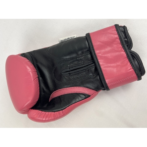 1333 - A pink and black leather Reebok boxing glove signed by welterweight and lightweight champion Amir Kh... 