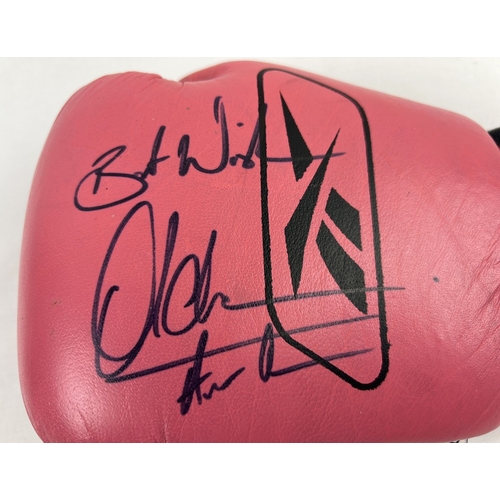 1333 - A pink and black leather Reebok boxing glove signed by welterweight and lightweight champion Amir Kh... 