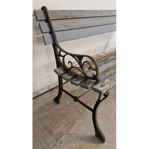 1421 - A wooden slatted garden bench with cast iron ends with scroll detail. Approx. 68cm tall x 122cm long... 