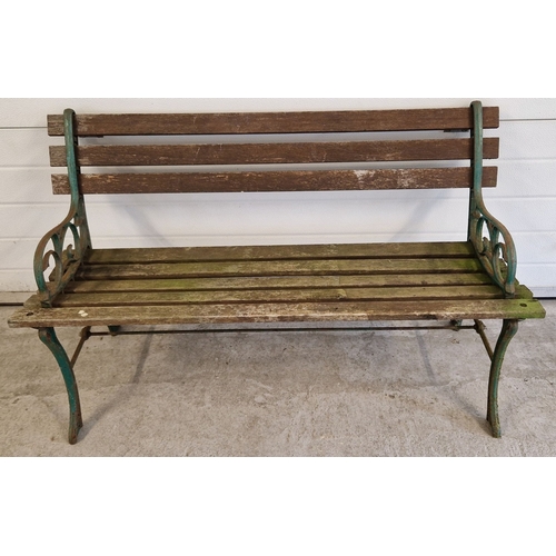 1434 - A wooden slatted garden bench with cast iron ends, painted green, with scroll detail. Approx. 122cm ... 