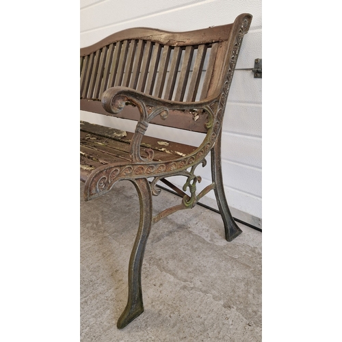 1467 - A wooden slatted garden bench with cast iron bench ends. Approx. 128cm long.