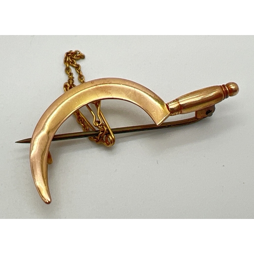 1123 - An Edwardian unmarked gold brooch in the shape of a hand scythe, with safety chain. No gold marks bu... 