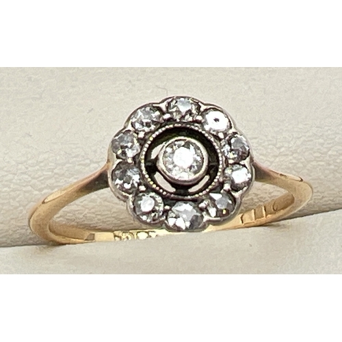 30003 - An Art Deco 18ct gold Halo set diamond ring. Central round cut diamond with 10 smaller round cut dia... 