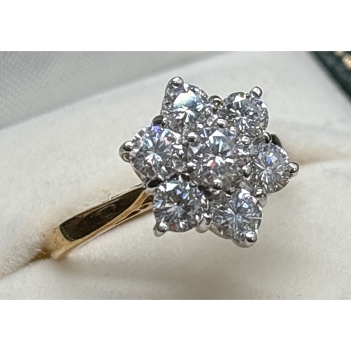 5 - A 18ct gold seven stone brilliant cut diamond flower design cluster ring. Stones in 18ct white gold ... 