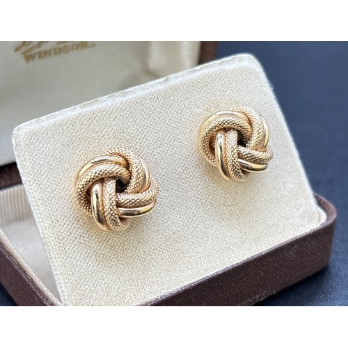 12 - A Large pair of vintage 9ct gold knot design stud earrings in plain and diamond patterned gold. Hall... 