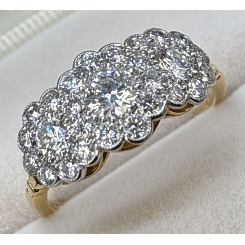 22 - An 18ct gold & diamond triple cluster ring set with 27 brilliant cut diamonds. Mounted in platinum m... 