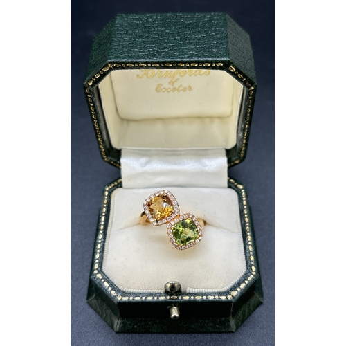 24 - An 18ct gold citrine, peridot and diamond double cluster ring in an offset crossover style.  A 1.4ct... 