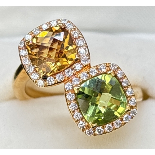 An 18ct gold citrine, peridot and diamond double cluster ring in an offset crossover style.  A 1.4ct checkerboard cushion cut citrine and 1.63ct peridot each surrounded by 20 small round cut diamonds. 40 diamonds total, with weight of approx. 0.28ct. Full hallmarks to inside of shank. Size M½. Total weight approx. 8.1g.