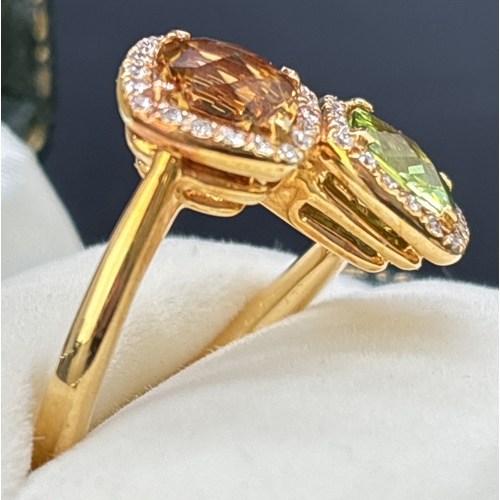 24 - An 18ct gold citrine, peridot and diamond double cluster ring in an offset crossover style.  A 1.4ct... 