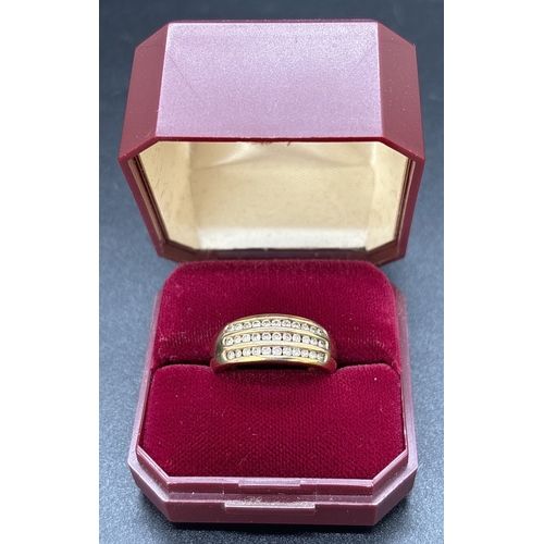 25 - A 9ct gold band ring set with 3 rows of channel set round cut diamonds totaling 0.5ct. Gold and diam... 