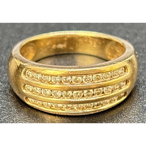 25 - A 9ct gold band ring set with 3 rows of channel set round cut diamonds totaling 0.5ct. Gold and diam... 