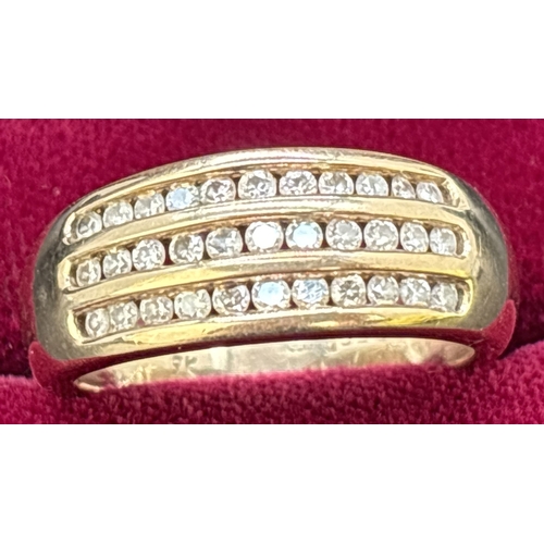 25 - A 9ct gold band ring set with 3 rows of channel set round cut diamonds totaling 0.5ct. Gold and diam... 