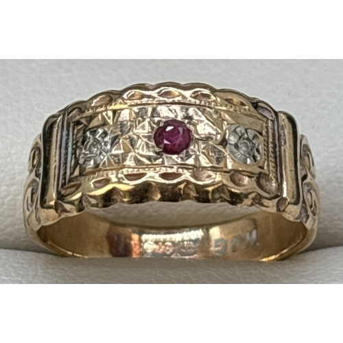 31 - An Edwardian style 9ct gold band ring set with a ruby and 2 small diamonds. Fluted edges with scroll... 