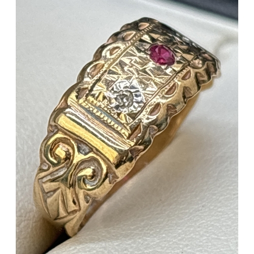 31 - An Edwardian style 9ct gold band ring set with a ruby and 2 small diamonds. Fluted edges with scroll... 