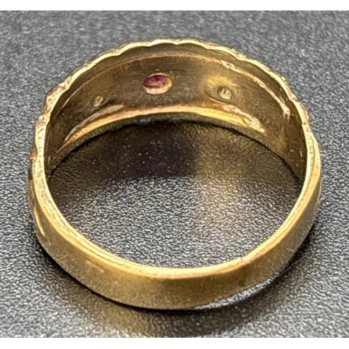 31 - An Edwardian style 9ct gold band ring set with a ruby and 2 small diamonds. Fluted edges with scroll... 