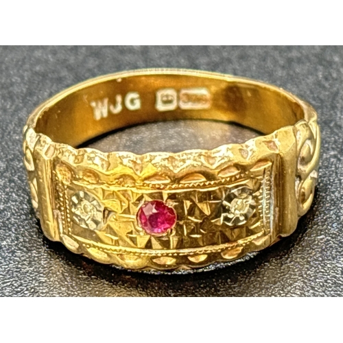 31 - An Edwardian style 9ct gold band ring set with a ruby and 2 small diamonds. Fluted edges with scroll... 