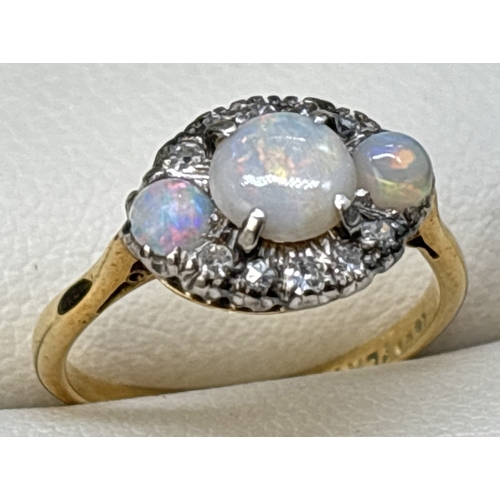 38 - A vintage 18ct yellow gold and platinum opal and diamond ring. Round cut central opal flanked by 2 s... 