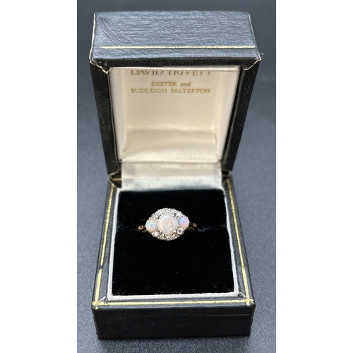 38 - A vintage 18ct yellow gold and platinum opal and diamond ring. Round cut central opal flanked by 2 s... 