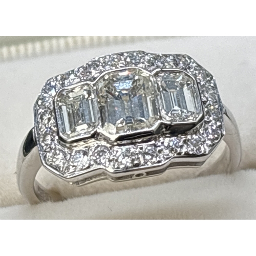 42 - An Art Deco design 18ct white gold and diamond ring. Comprising 3 rub over set emerald cut diamonds ... 