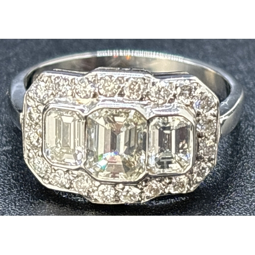 42 - An Art Deco design 18ct white gold and diamond ring. Comprising 3 rub over set emerald cut diamonds ... 