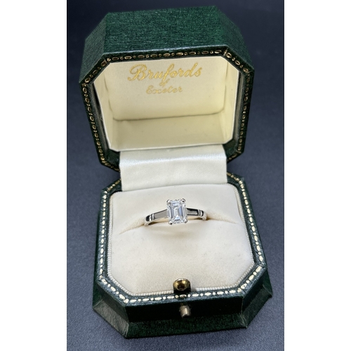 43 - A single stone 1.05ct emerald cut diamond ring mounted in a platinum four claw setting with parallel... 