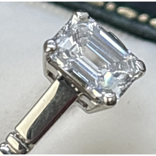 43 - A single stone 1.05ct emerald cut diamond ring mounted in a platinum four claw setting with parallel... 