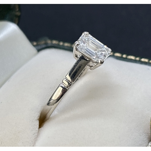 43 - A single stone 1.05ct emerald cut diamond ring mounted in a platinum four claw setting with parallel... 