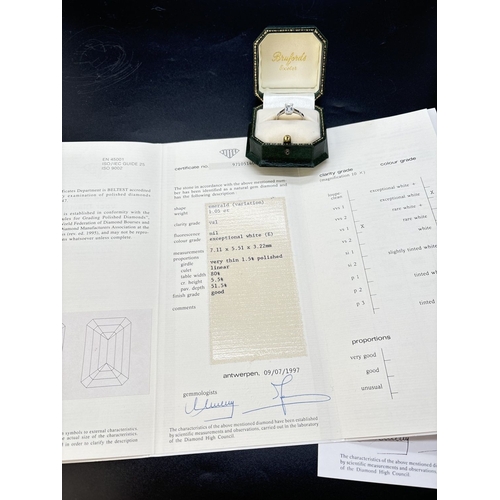 43 - A single stone 1.05ct emerald cut diamond ring mounted in a platinum four claw setting with parallel... 