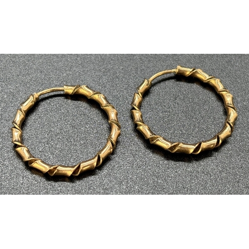 54 - A pair of twist design 9ct gold hoop earrings. Gold marks to posts. Approx. 2.5cm diameter. Weight a... 