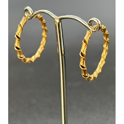 54 - A pair of twist design 9ct gold hoop earrings. Gold marks to posts. Approx. 2.5cm diameter. Weight a... 