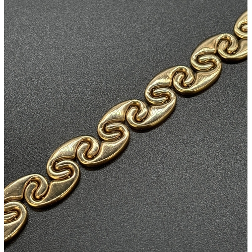 57 - A 9ct gold 7.5 inch interlocking curved link bracelet with push clasp and safety clip. Gold marks to... 