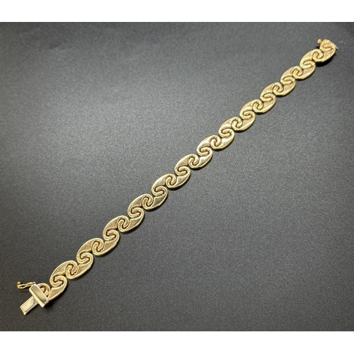 57 - A 9ct gold 7.5 inch interlocking curved link bracelet with push clasp and safety clip. Gold marks to... 