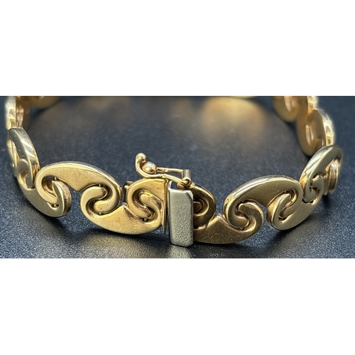 57 - A 9ct gold 7.5 inch interlocking curved link bracelet with push clasp and safety clip. Gold marks to... 