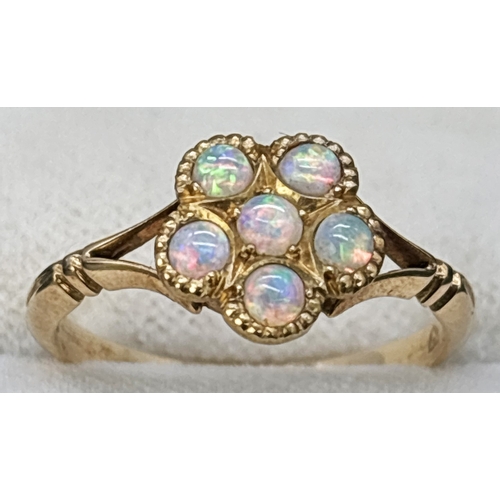 61 - An 18ct yellow gold opal set dress ring. 6 small round opals in a flower head design with split shou... 