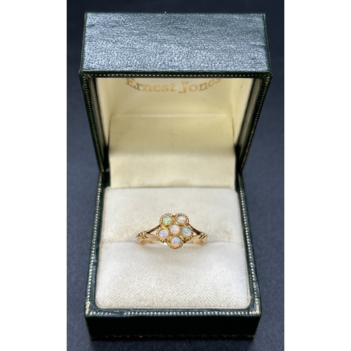 61 - An 18ct yellow gold opal set dress ring. 6 small round opals in a flower head design with split shou... 