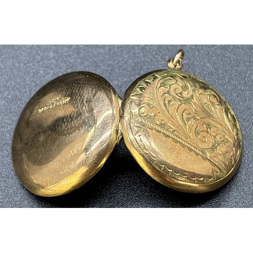 67 - A vintage 9ct gold front and back circular shaped locket with floral engraved decoration and empty c... 