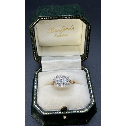 69 - An 18ct yellow gold diamond cluster ring comprising 3 emerald cut claw set central diamonds surround... 