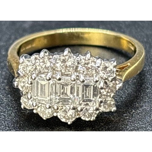 69 - An 18ct yellow gold diamond cluster ring comprising 3 emerald cut claw set central diamonds surround... 