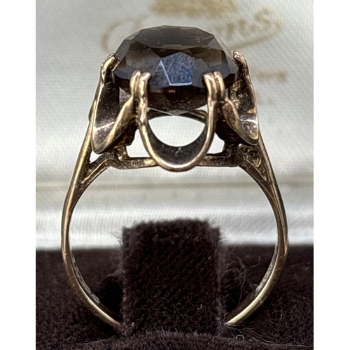 84 - A vintage 9ct yellow gold dress ring with a claw set oval cut smoked quartz stone in a scallop edge ... 