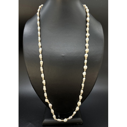 87 - A vintage 28 inch alternating freshwater keshi pearl and 9ct gold round bead necklace. With 9ct gold... 