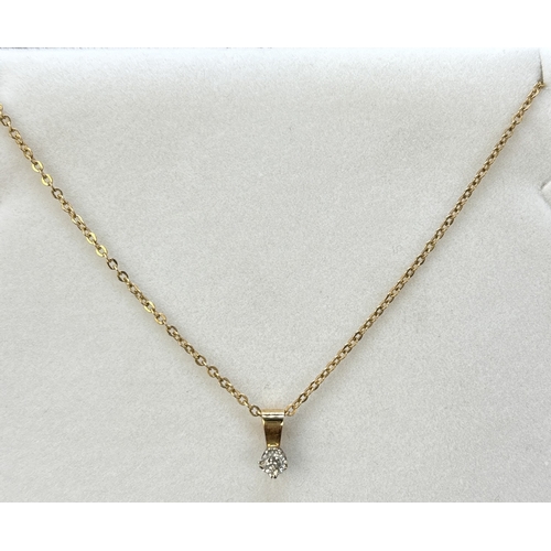 90 - An unmarked 9ct gold single stone 0.15ct diamond pendant on an 18