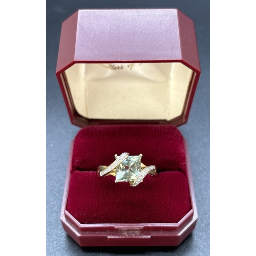 97 - A 9ct gold wrap over design green amethyst and diamond dress ring. Central square cut green amethyst... 