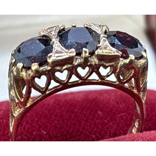 102 - A vintage 9ct gold gypsy style garnet set trilogy ring. High mount and shoulders with pierced work h... 