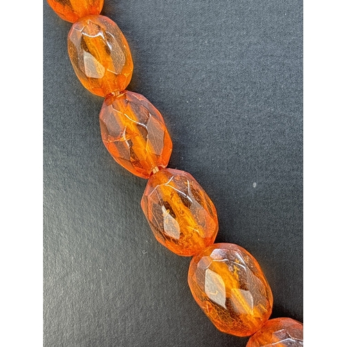 111 - A vintage 20 inch facet cut graduating amber bead necklace with push clip clasp. Total weight approx... 