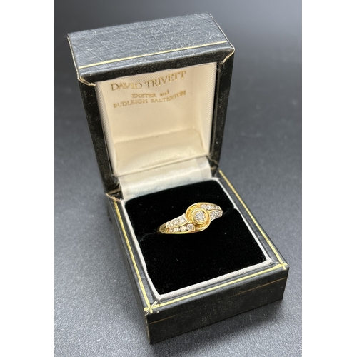 116 - A twist design 0.25ct diamond set 18ct yellow gold ring. Central round cut bezel set diamond with a ... 