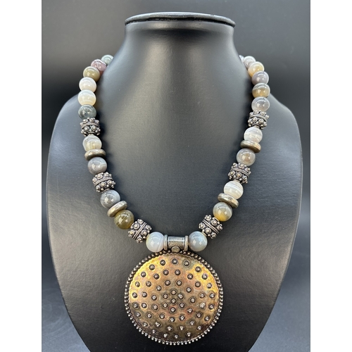 121 - A modern design 18 inch banded agate and silver bead necklace with large circular pendant and lobste... 