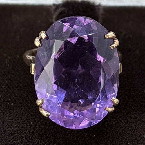 124 - A vintage unmarked yellow gold cocktail ring with large oval cut amethyst in a double pronged open w... 